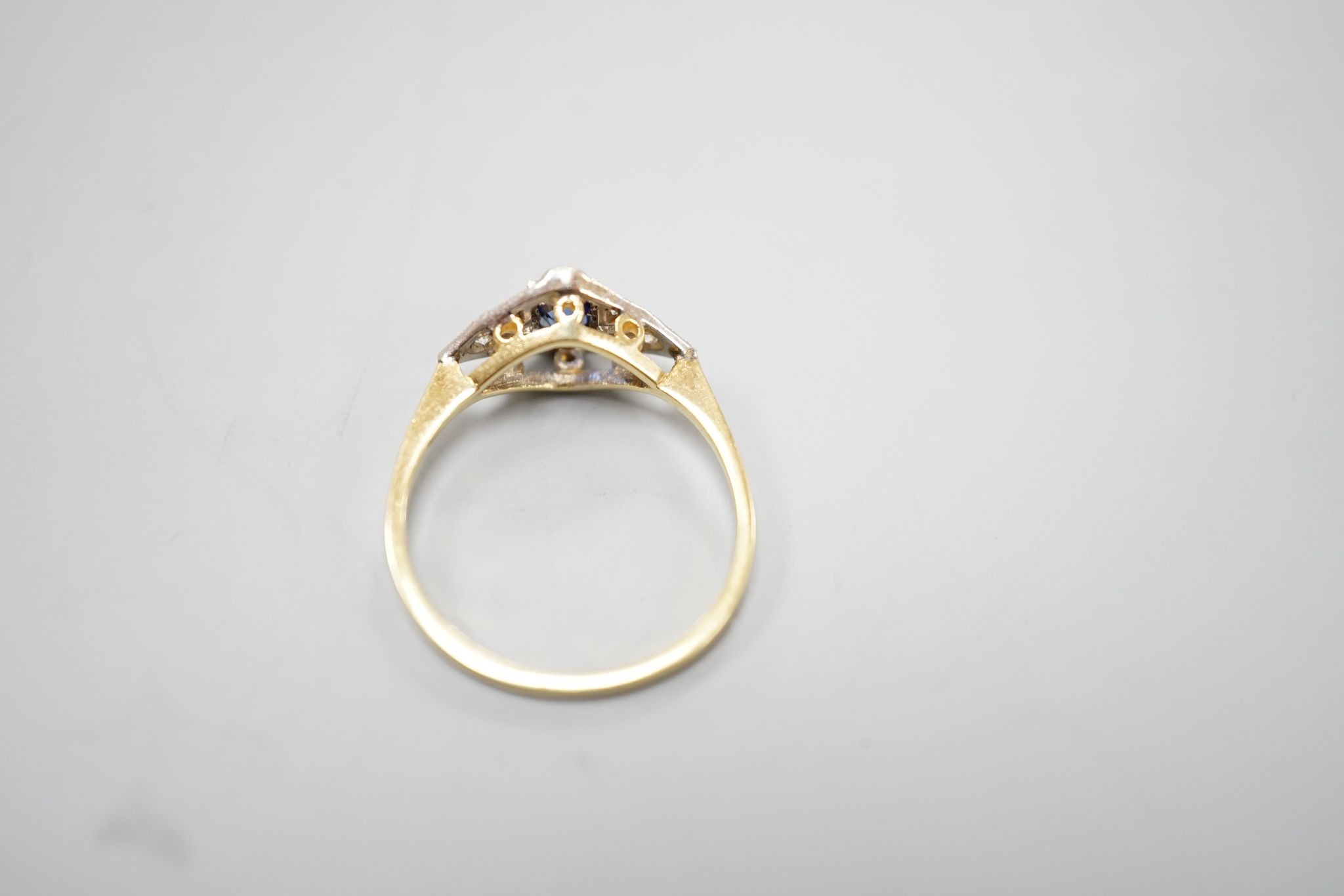 A 1920's 18ct, sapphire and diamond set shaped cluster ring, size N, gross weight 2.5 grams.
